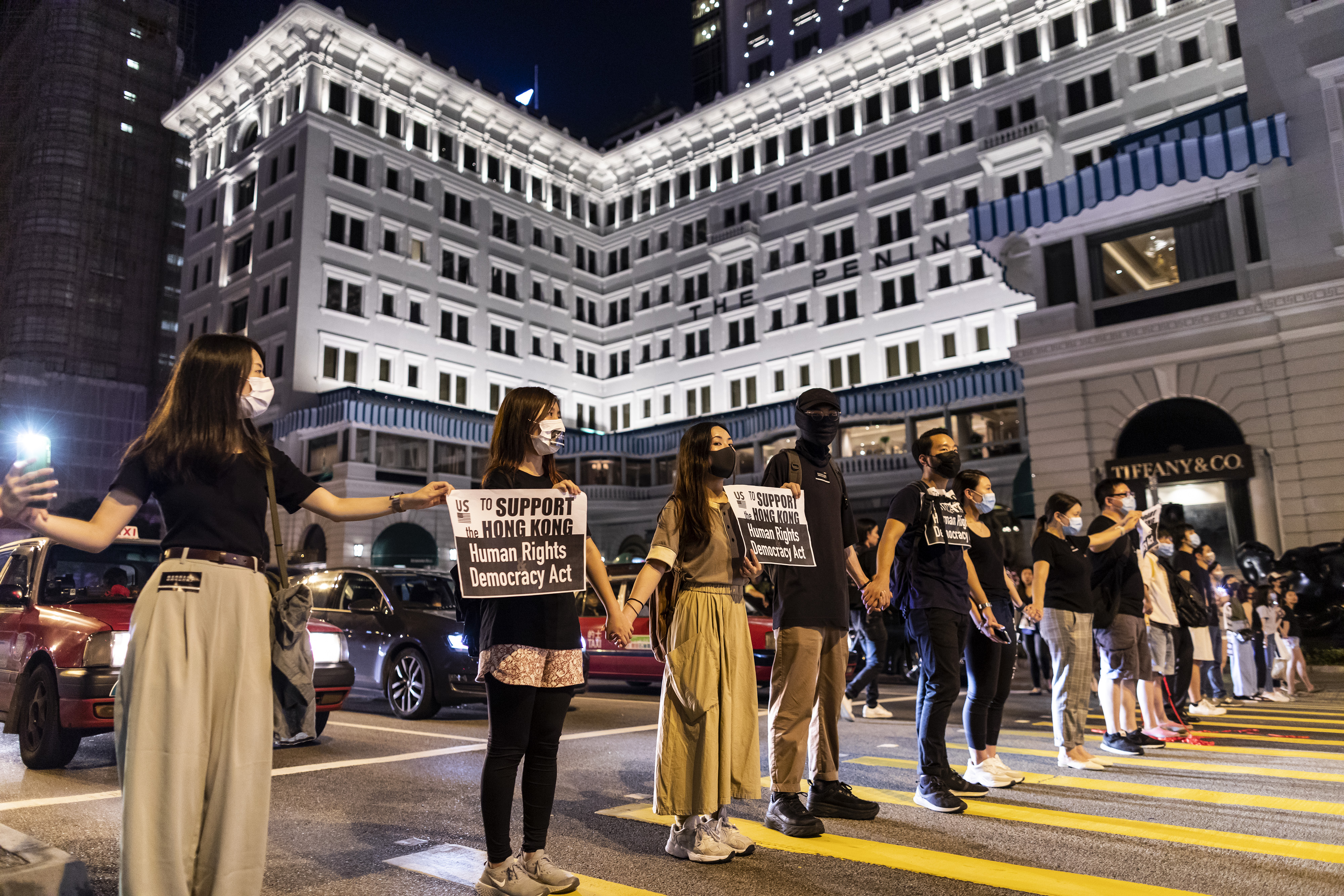 Demonstrators join hands to form a human chain in front of the Peninsula Hotel during the Hong Kong Way event in the Tsim Sha Tsui district of Hong Kong, China, on Friday, Aug. 23, 2019.