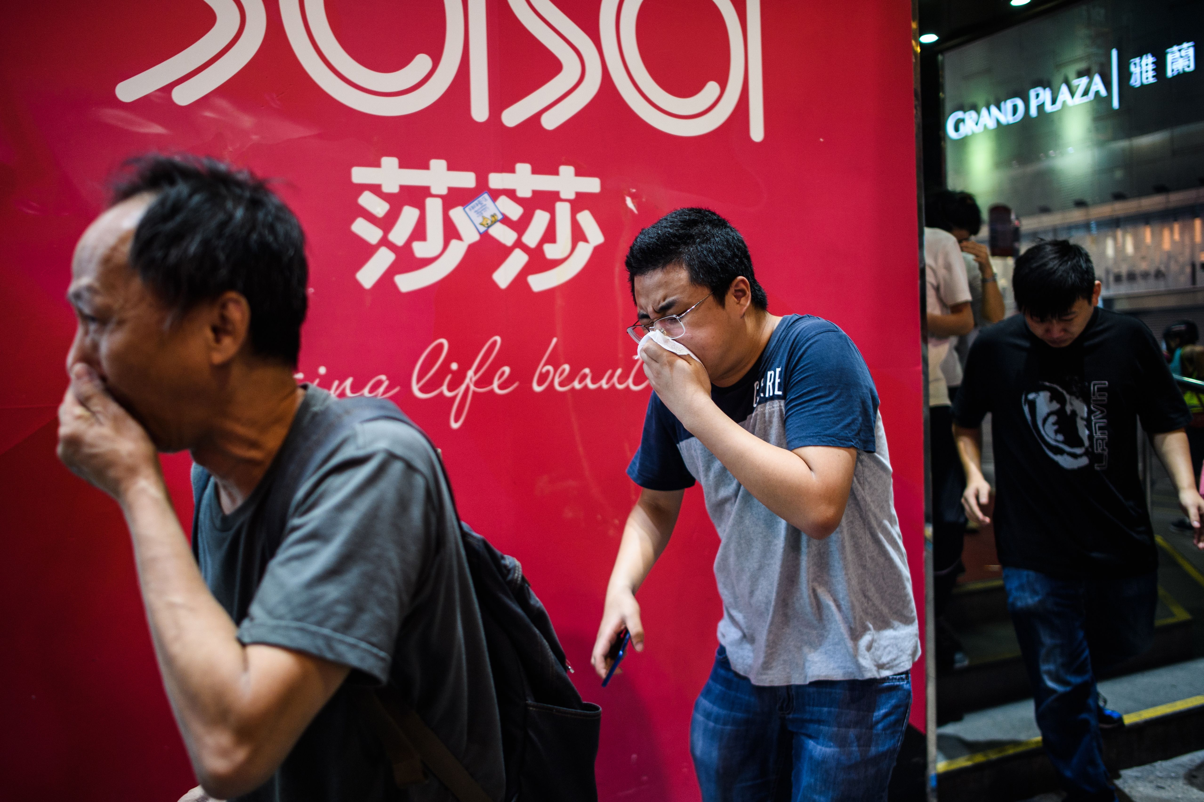 Bystanders react after police fired tear gas to disperse residents and protesters in the Mong Kok district of Kowloon in Hong Kong on October 27, 2019.