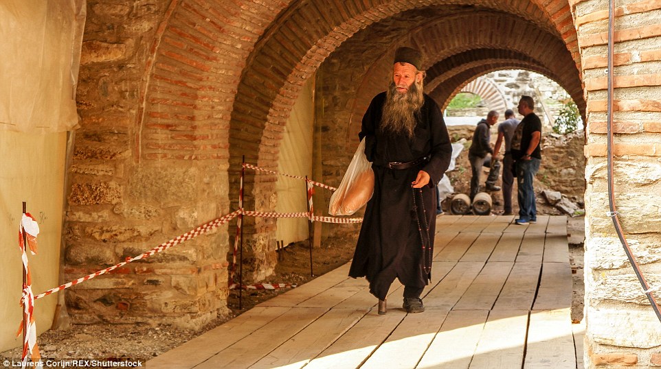 The fascinating photographs show black-clad bearded monks and priests wandering around their pine-covered mountain haven