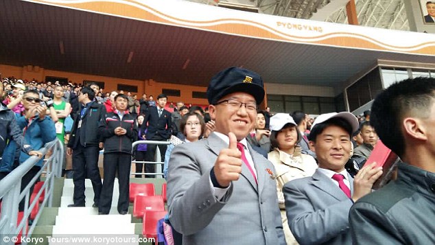 A man gives the thumbs up to the camera at the closing ceremony of the huge stadium