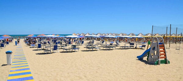 Лежаки, зонтики и детская горка на пляже в городе Монтесильвано, Италия